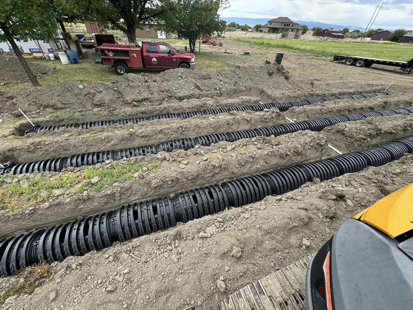 Rows of black drainage chambers laid in excavated trenches