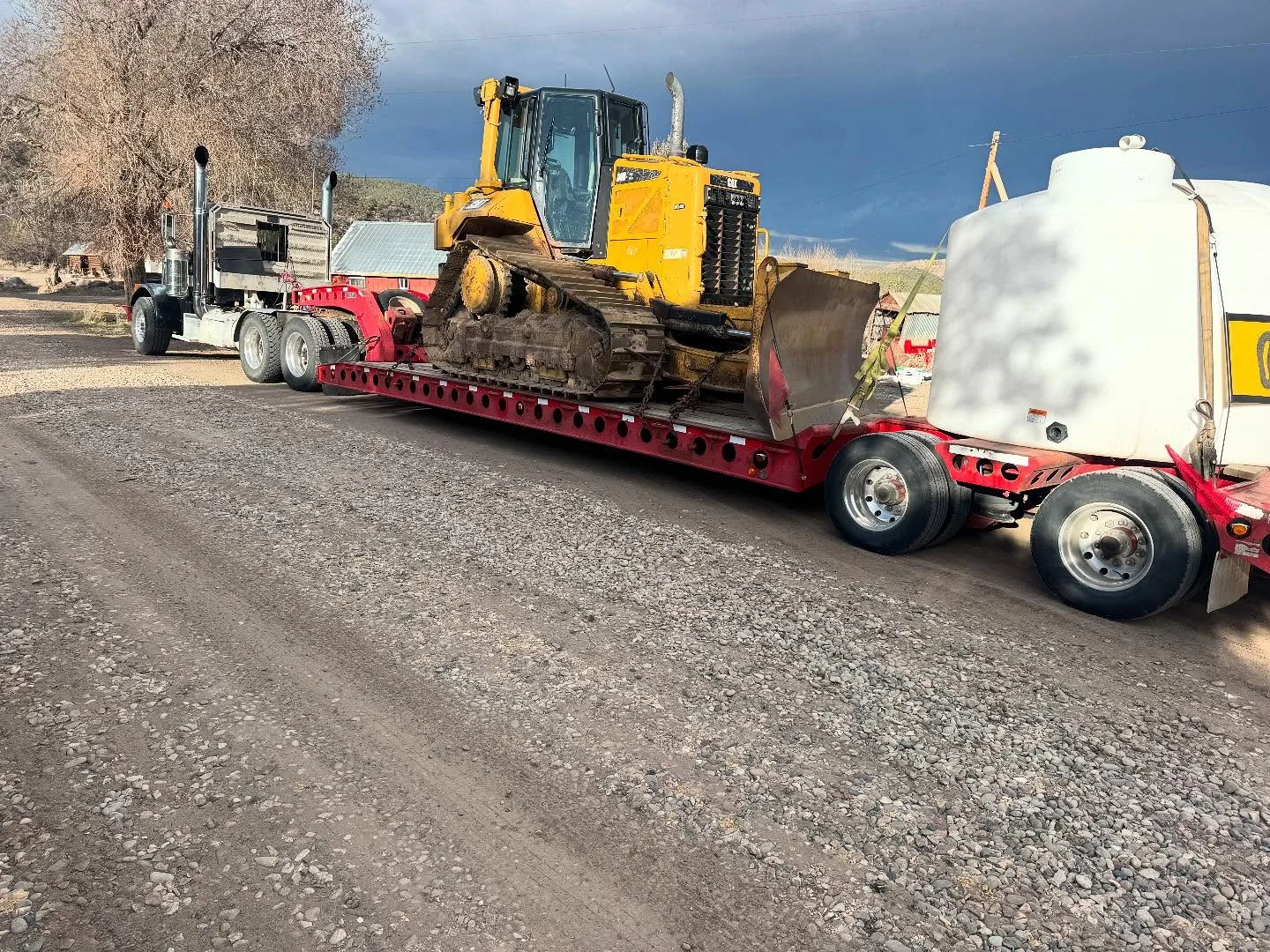 Tracked loader secured on a lowboy equipment trailer