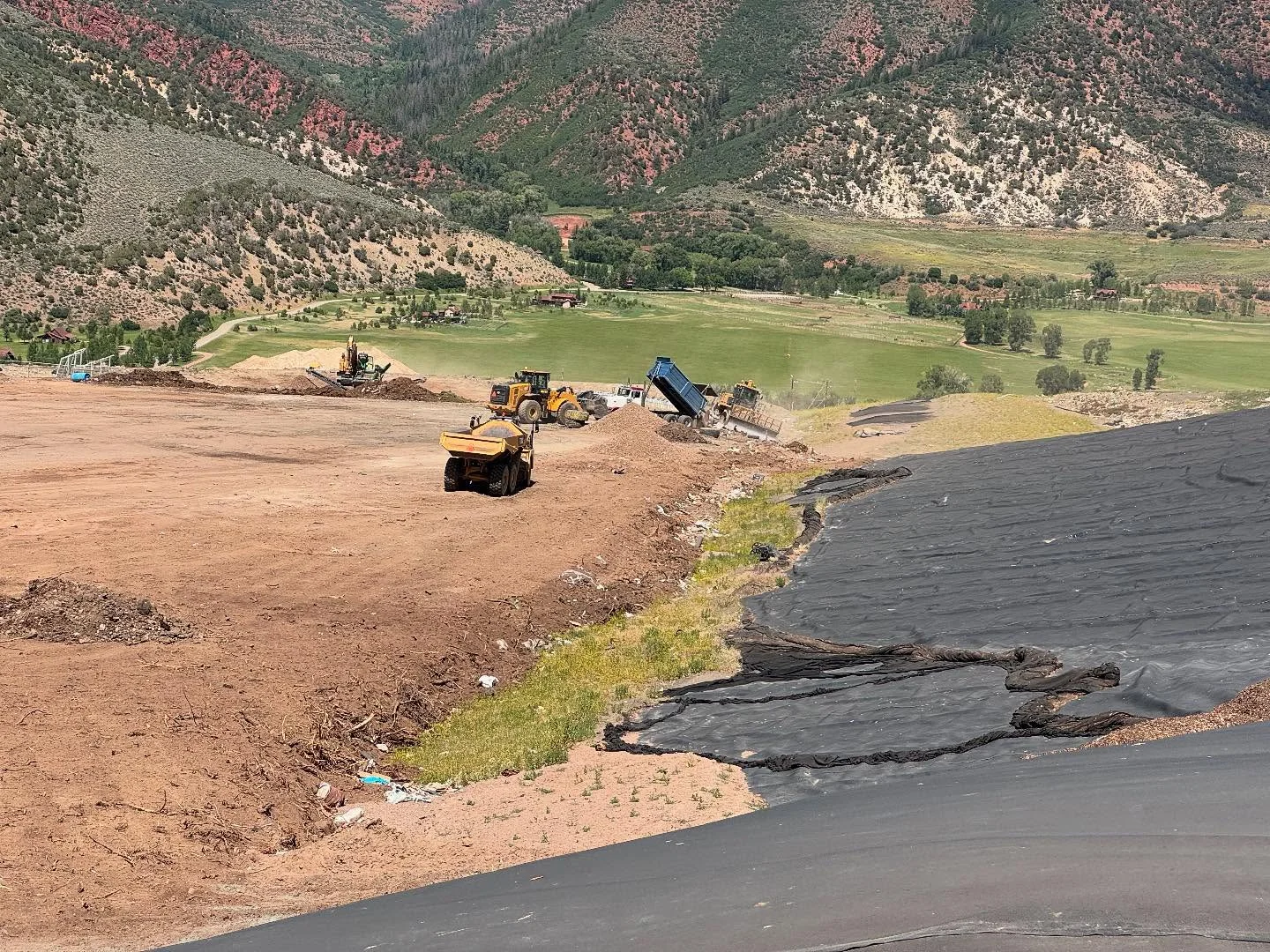 Excavation and grading equipment preparing a large site in a mountain valley