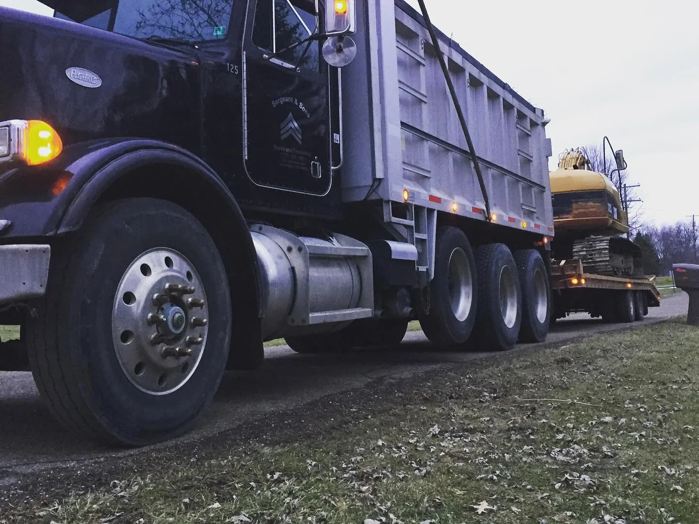 Dump truck hauling an excavator on a trailer